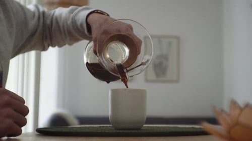 Pouring Coffee into Cup in Home