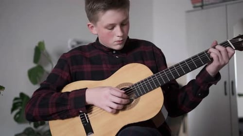 Teenager Plays Guitar Indoors
