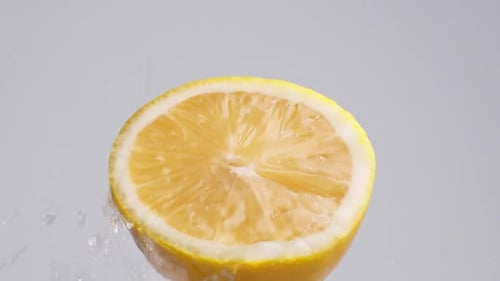 Refreshing Half Lemon with Pouring Water Close Up