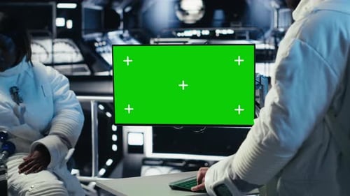 Astronaut Monitoring Diagnostics on Green Screen Display Talking to Colleague
