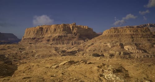 Vast Desert Landscape with Rugged Cliffs Under Clear Blue Sky