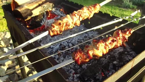 Cooking, Barbecue and Food Concept - Shashlik Hand Turning Skewers with Meat