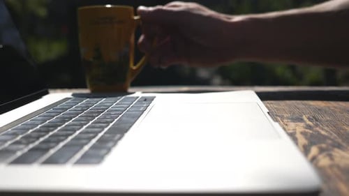 Unbekannter Mann arbeitet nach der Kaffeepause am Arbeitsplatz weiter mit Notizbuch
