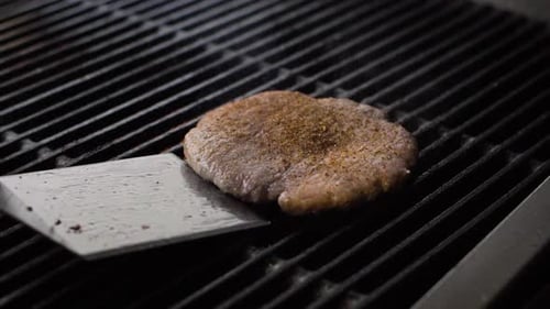 Chef Cooking Beef Patty for Burger on Hot Grill and Flip the Cutlet with a Spatula