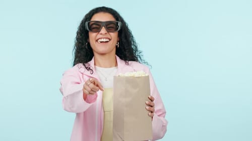 Popcorn, funny or happy woman watching movie in studio for television or cinema to relax