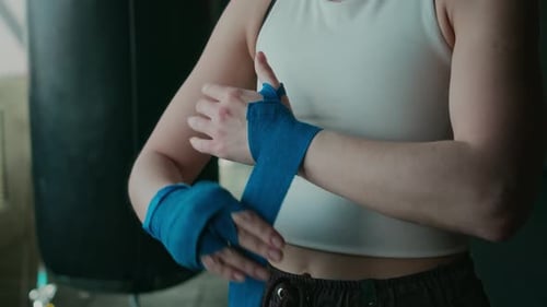 Woman Wrapping Hands for Boxing Training at Gym