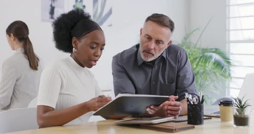Two business people talking about a design in an office