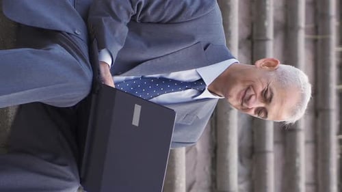 Man Smiling Using Laptop on Concrete Steps