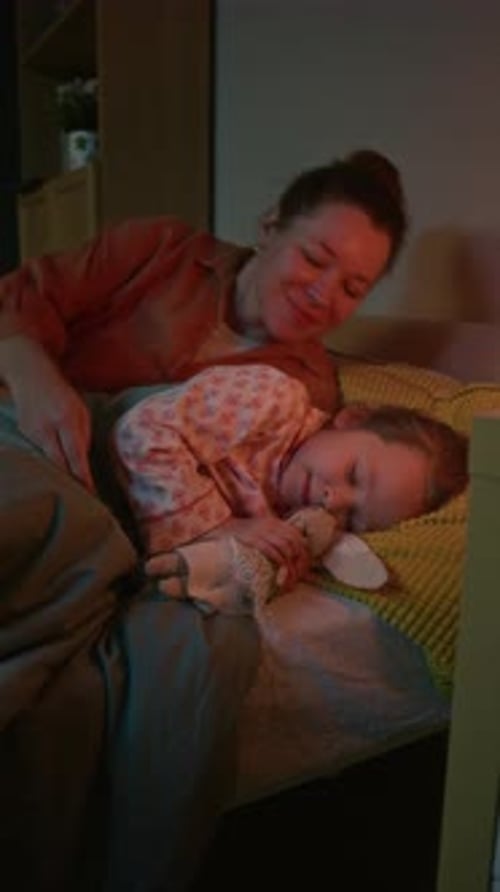 Kid Lying in Bed while Her Mother Hugging Her