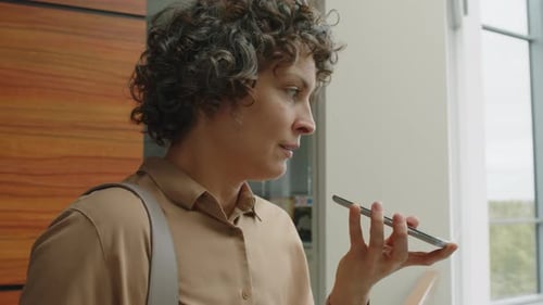 Woman Uses Voice Command on Smartphone Indoors