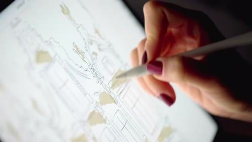 Woman hands painting with white pencil on tablet pc at night