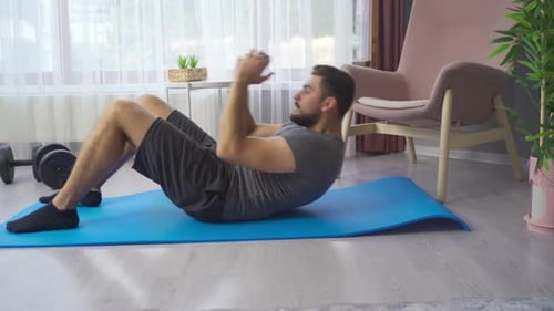 Man Doing Sit-ups on Yoga Mat at Home