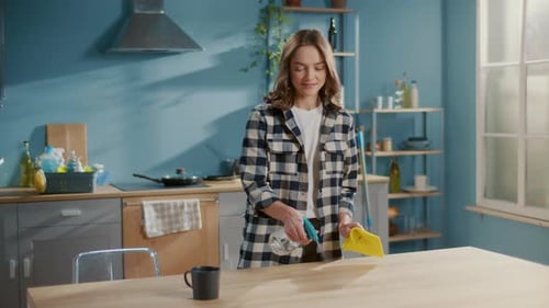 Young Woman Cleaning Table in Sunny Kitchen