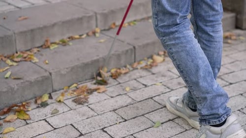 Blinder Mann klettert die Stufen hinauf