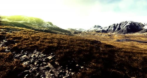 Majestic Mountain Landscape at Golden Hour with Lush Grass and Rocky Terrain