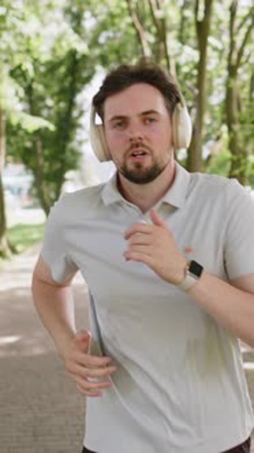 Athletic Fitness Sport Jogger Man Training Marathon Run Listening Music in Headphones Morning Park