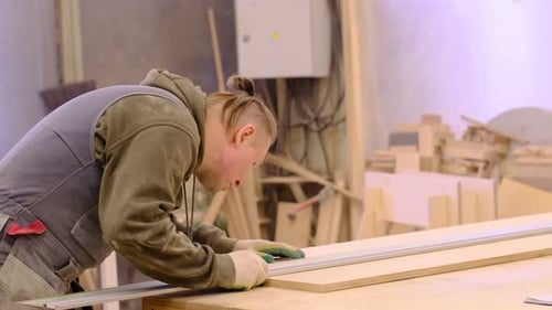 Close Up Carpenter at Workshop Polishes Wooden Board with a Electric Orbital Sander Woodwork and