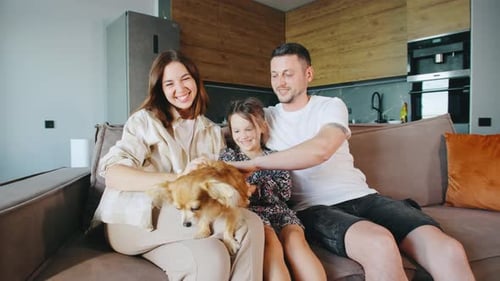 Happy Family with Dog Relaxing on Couch