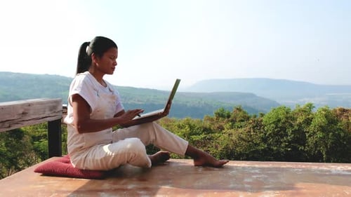 Remote Online Working Digital Nomad Women and Laptop Sitting Outside in Mountains of Thailand