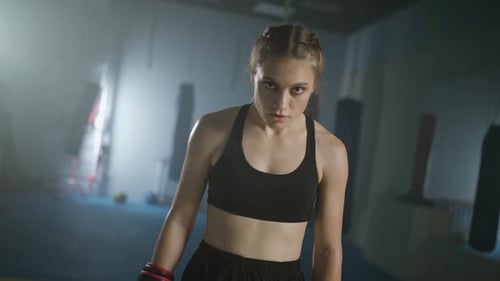 Portrait of a Woman Pro Fighter Standing in a Boxing Gym and Looking Into the Camera Woman Power
