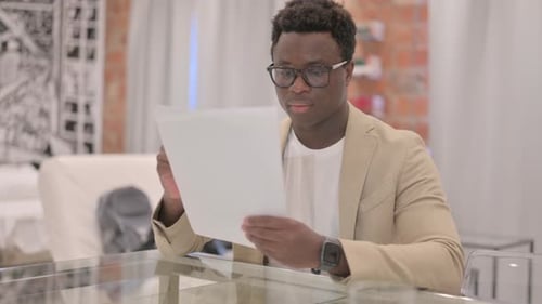 Young Adult Reviewing Documents at Table