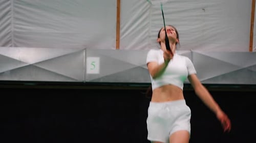 Sports Young Woman with Racket and Shuttlecock is Exercising Playing in Badminton on Inside Court