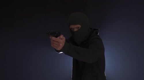 Man in Balaclava Aims Gun in Dark
