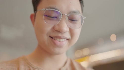 Close-up of a happy man sitting typing a message on his smartphone in a chat app.