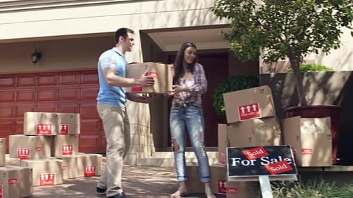 Young Couple Moving into New Home with Boxes