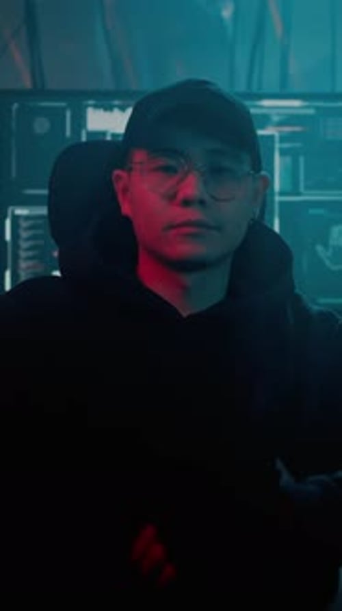 Young Adult Coding in Dark Futuristic Workplace