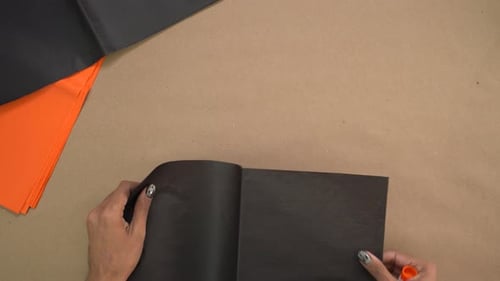 Laying out black and orange colored tissue paper to make crafts