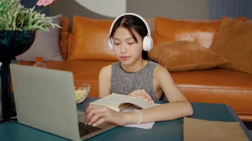 Teen Girl Studies with Laptop and Textbook at Home