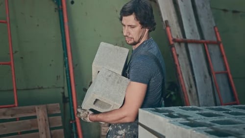 Lowskilled Construction Labor A Man Works As a Loader and Carries Heavy Building Blocks