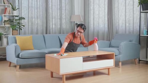 Man Cleaning Table with Spray in Living Room