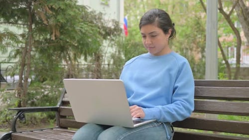 Woman Working on Laptop in City Park