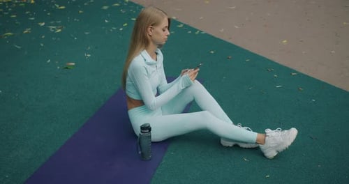 Female Hands Hold Smartphone Typing and Send Message After Workout Outdoors