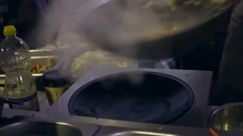 Chef Cooking Vegetables in Steaming Wok at Night