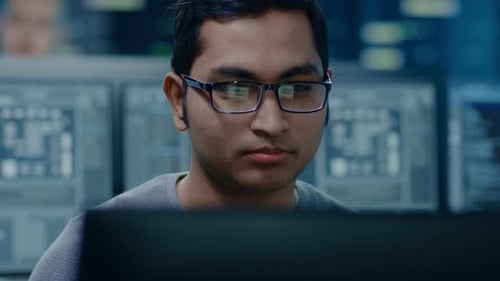 Focused man working with computers in a modern office