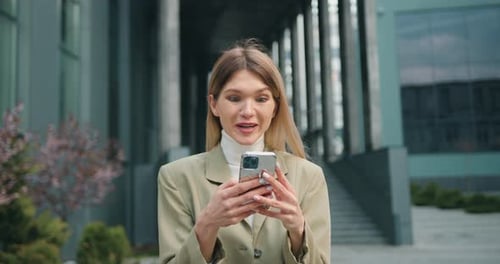 Woman user customer standing in urban street using smartphone, get amazing sale offer winning online