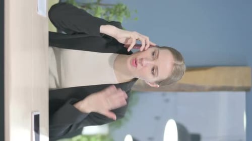 Woman Talking on Phone at Work Desk