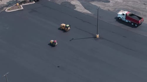 Group of Construction Workers Laying Asphalt Concrete on Parking Lot and Roadway Aerial Shot