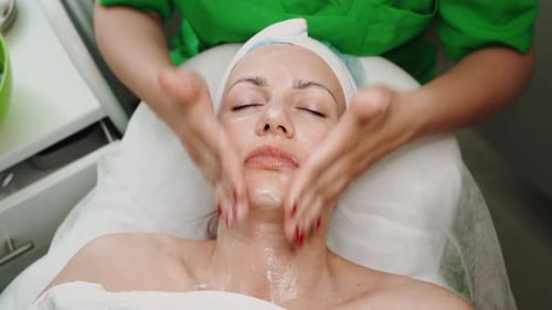 Gesichtspeeling-Maske Spa-Schönheitsbehandlung Hautpflege Frau bekommt Gesichtspflege von Kosmetikerin im Spa Salon