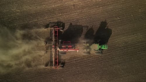 Green tractor seeding wheat on the field