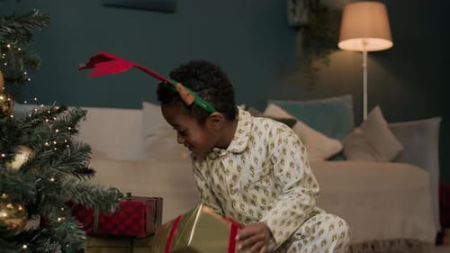 Happy Kid Shaking Gift Boxes On Christmas