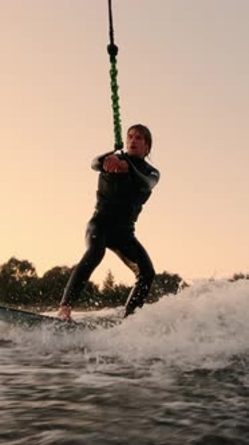 Man Wakeboarding on Water at Sunset