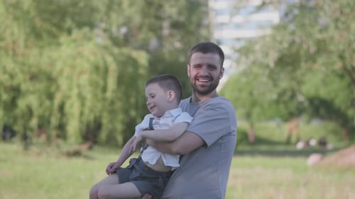 Cheerful Dad and Son Playing Together in the Park