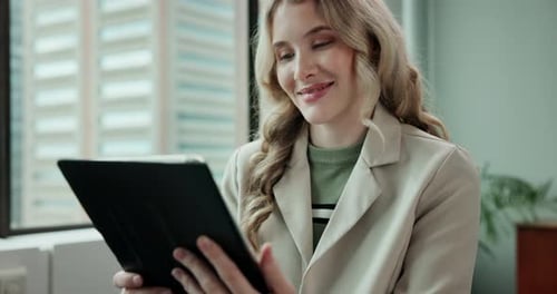 Woman Looks at Tablet in Workplace Setting