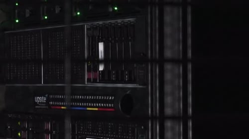 Data servers behind grid illuminated by white dim light. Concept of hack, hackers, cyberwar