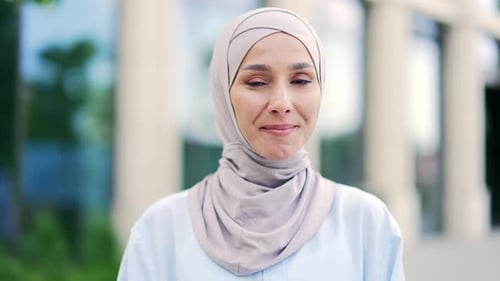 Nahaufnahme einer jungen positiven muslimischen Mitarbeiterin im Hijab, die dabei in die Kamera schaut