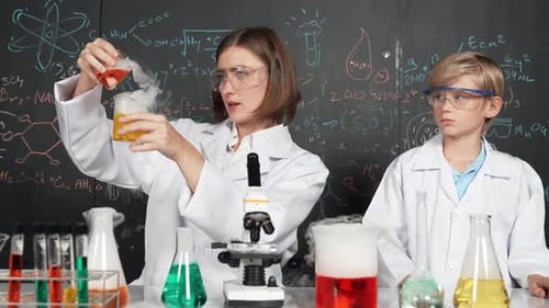 Woman and Boy Perform Chemistry Experiment in Science Lab